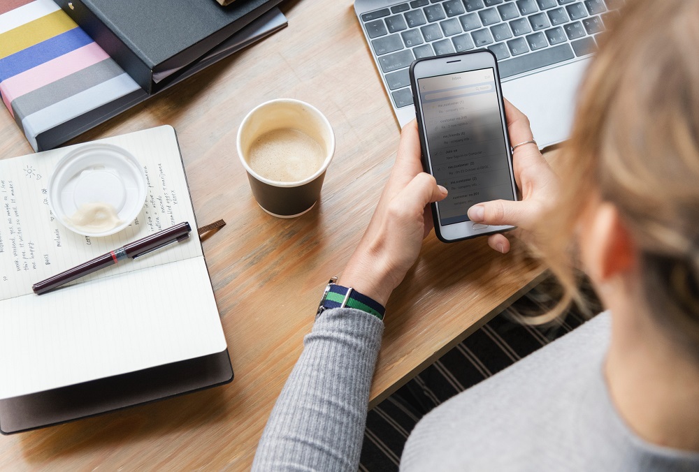 As a business person there is so much to do - image of a person with notebook, laptop and phone all open